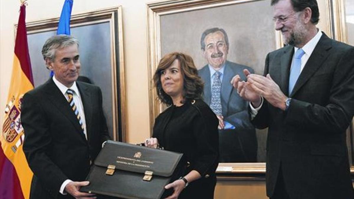 Sáenz de Santamaría recibe la cartera de manos de Jáuregui, en presencia de Rajoy, ayer.