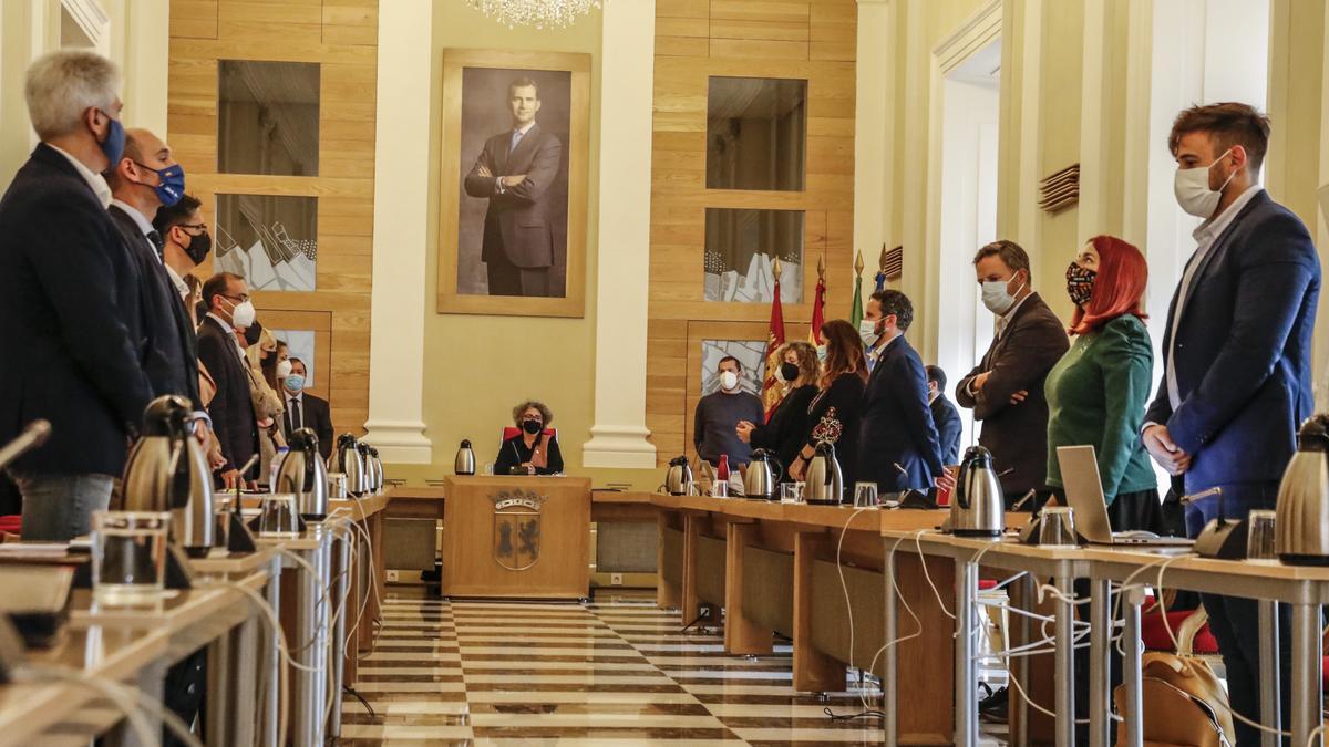 Miembros del pleno municipal, ayer, al empezar la sesión con un minuto de silencio por las víctimas del covid.