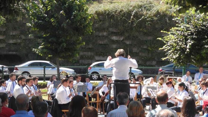 La Banda de Música de Candás interpreta pasodobles en el parque de Santarúa