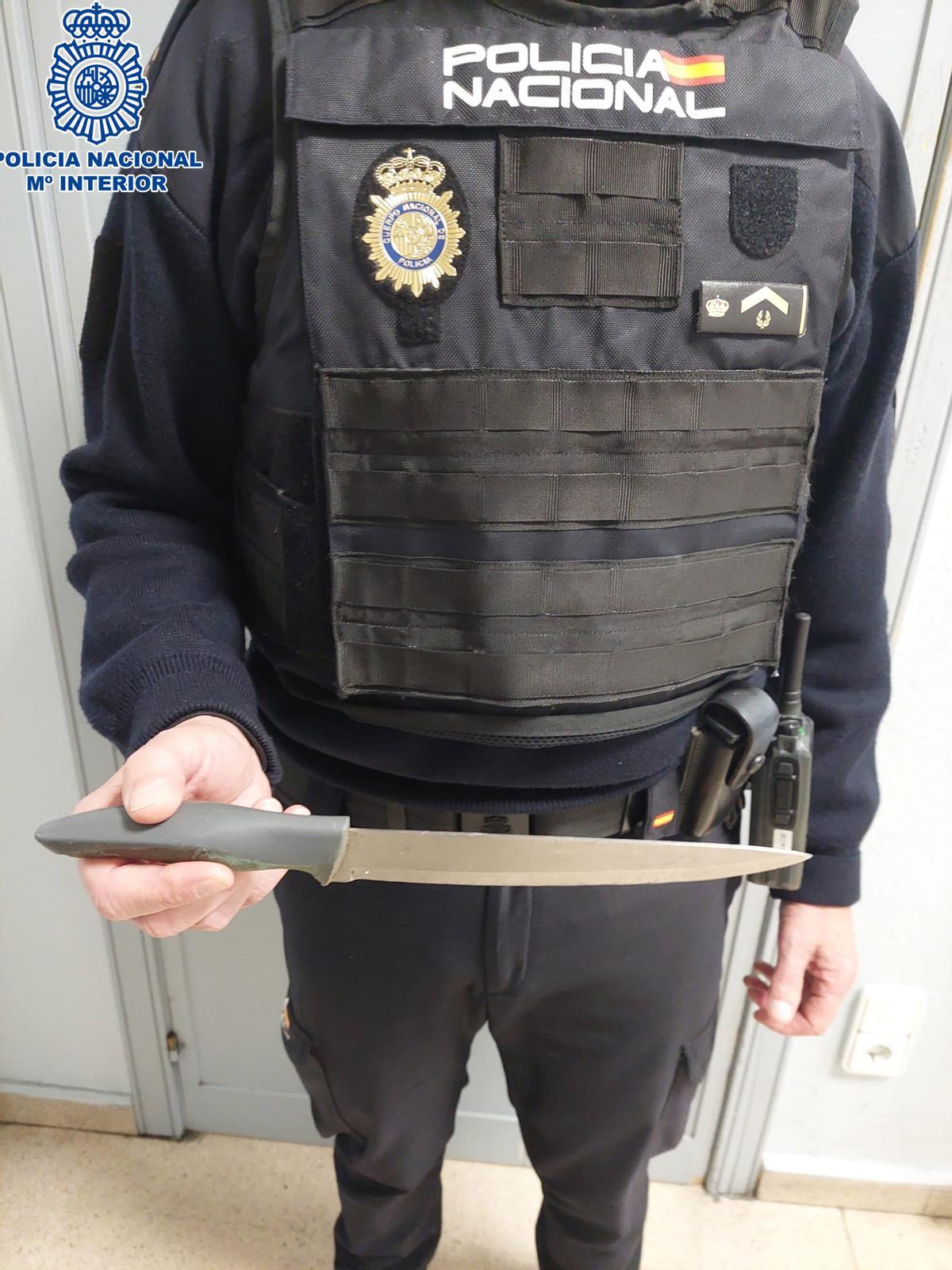 Un agente de la Policía Nacional posa con el cuchillo encontrado en el coche del detenido