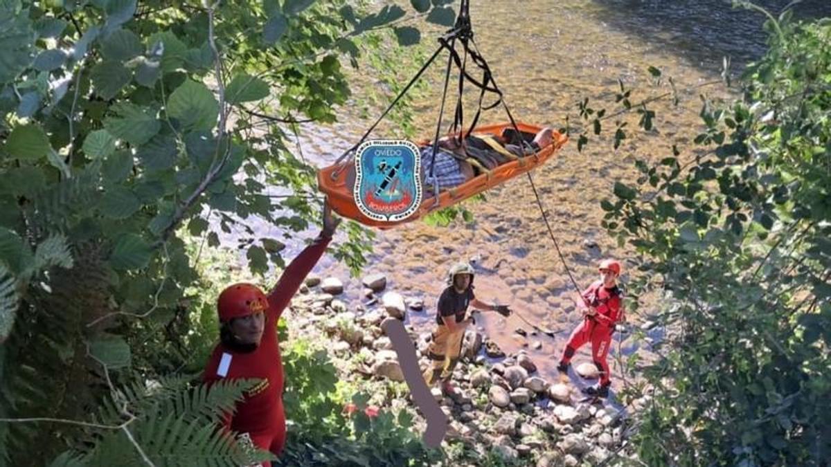 El momento en el que el herido es rescatado por el brazo del camión grúa desde el cauce del ruido.