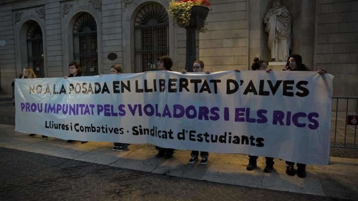 Un grupo de personas sostiene una pancarta durante una concentración en contra la petición de libertad de Dani Alves