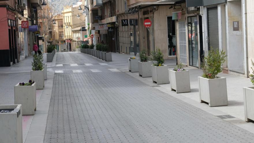 Una calle con todos sus comercios cerrados en Elda.