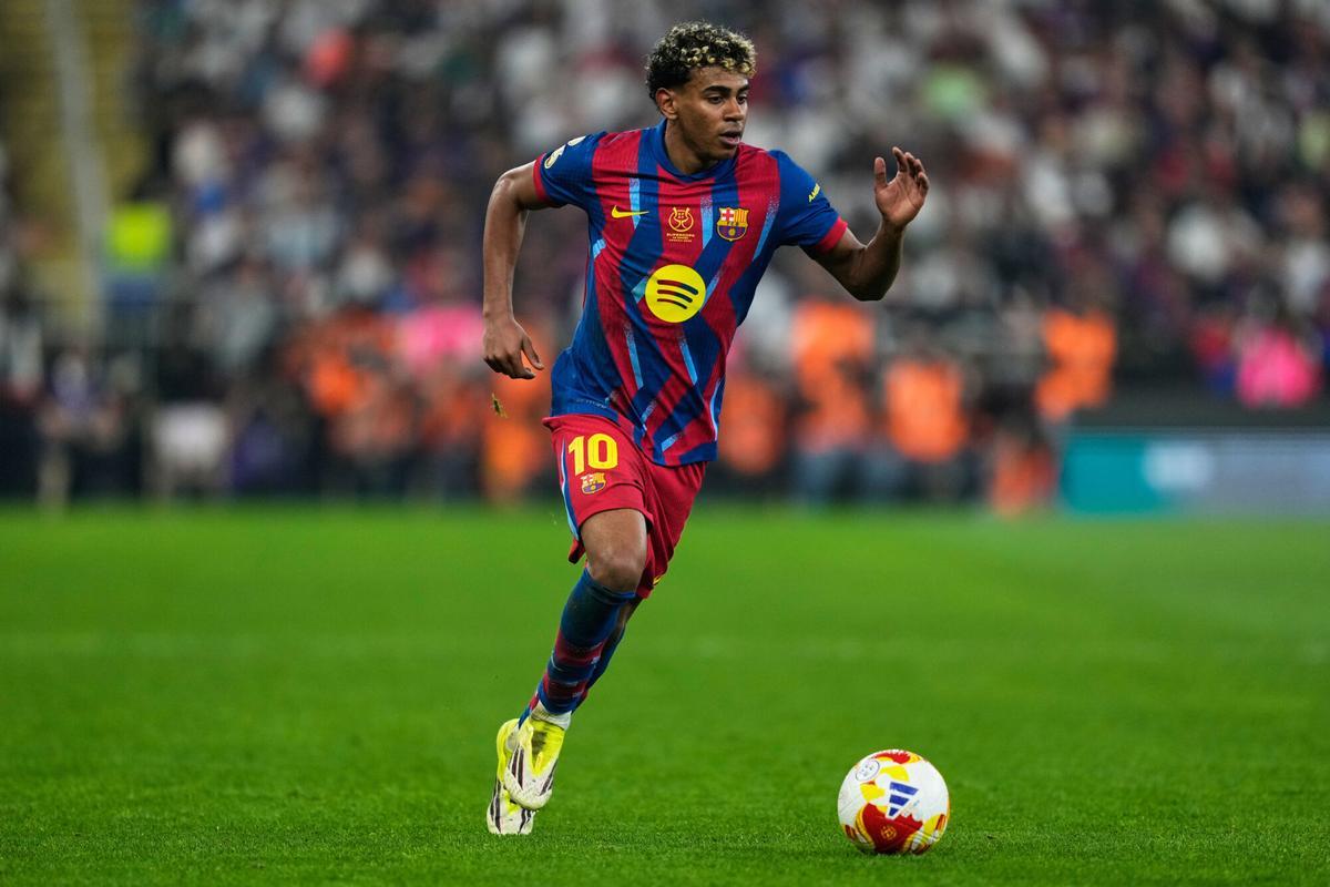 Barcelona's Lamine Yamal runs with the ball during the Spanish Super Cup final soccer match against Real Madrid at King Abdullah Sports City Stadium in Jeddah, Saudi Arabia, Sunday, Jan. 11, 2026. (AP Photo/Altaf Qadri)
