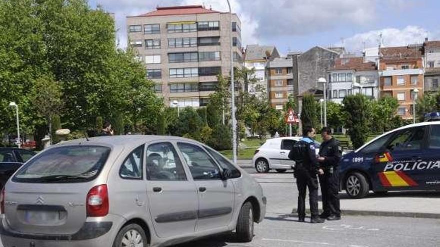 Dos agentes junto al coche implicado en el accidente. // Noé Parga