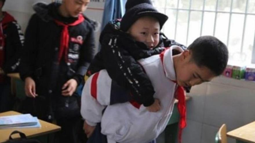 La foto viral de un niño que carga todos los días con su amigo, con hipotonía muscular