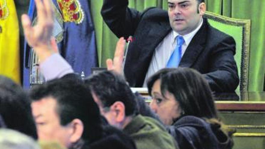 El Alcalde y los concejales del PP levantan la mano durante una votación.