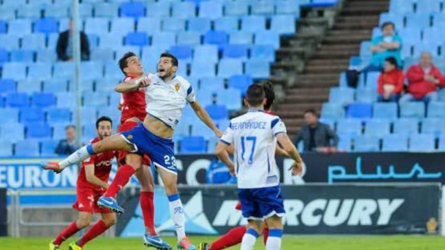 Javi Álamo disputa un balón aéreo con el sportinguista Bernardo en La Romareda.