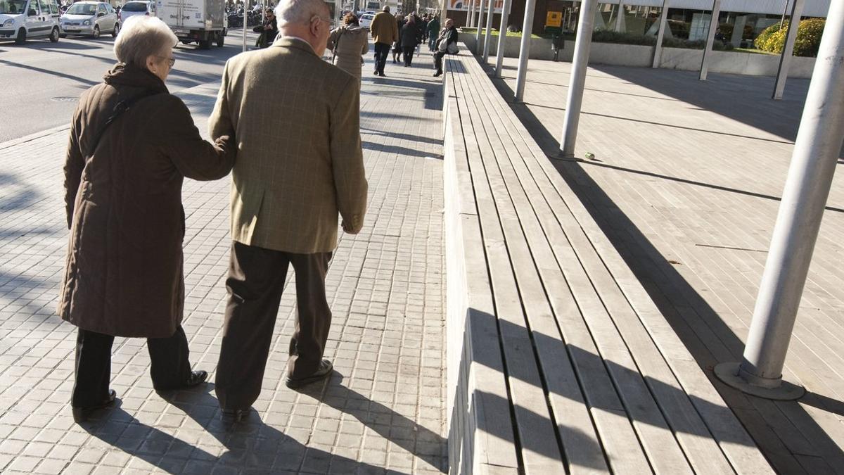 Dos ancianos caminan por una calle de Barcelona