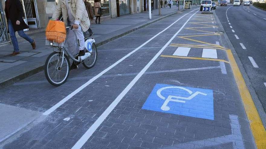 Un ciclista pasa por el carril bici de Primo de Rivera, junto a la zona de carga y descarga.