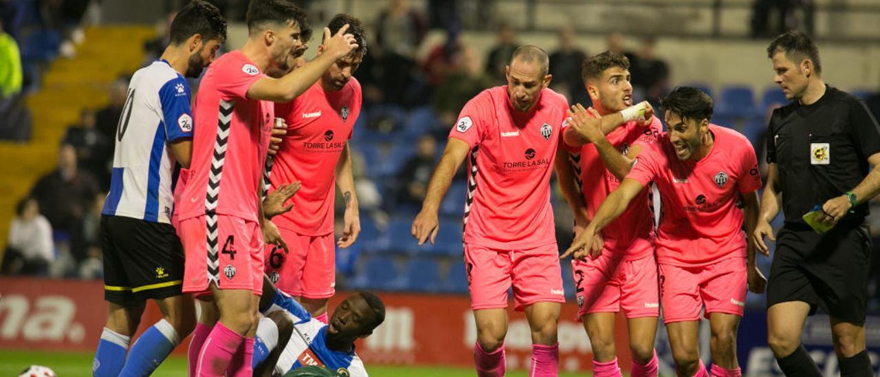 Cinco jugadores del Castellón protestan al árbitro la entrada de Emaná al portero que fue castigada con roja en la primera vuelta.