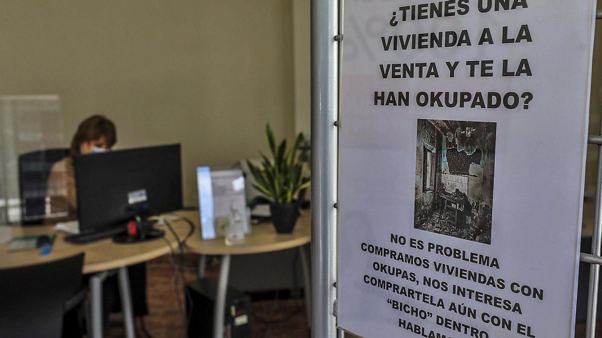 Una inmobiliaria de Elche en la que se puede leer el cartel en el que se anuncia que no es problema para la compra de viviendas que se encuentren okupadas actualmente. | ANTONIO AMORÓS