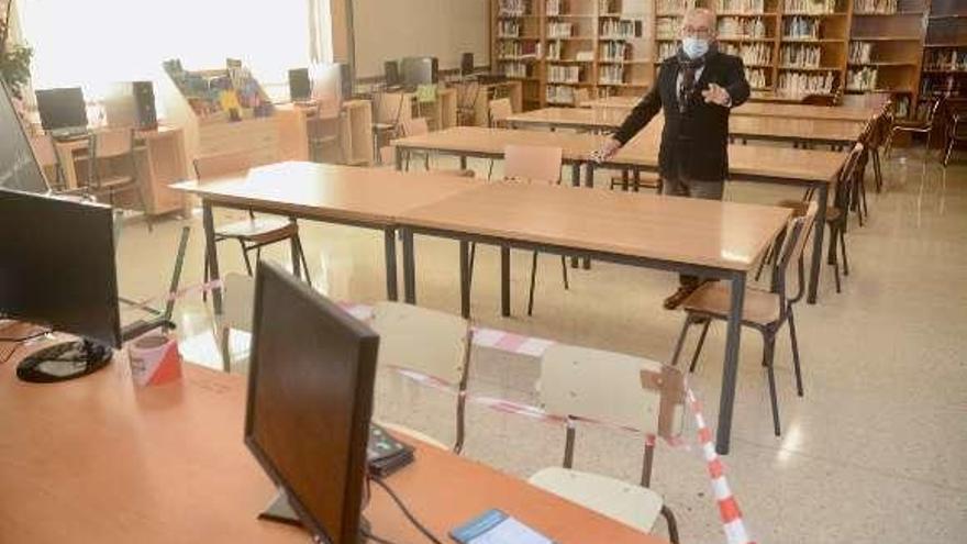 La secretaria del IES Valle Inclán y profesora de Biología mide la distancia entre mesas. // Rafa Vázquez