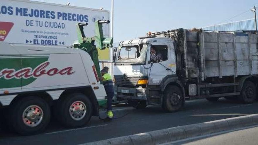 El camión siniestrado, ayer, remolcado por la grúa.