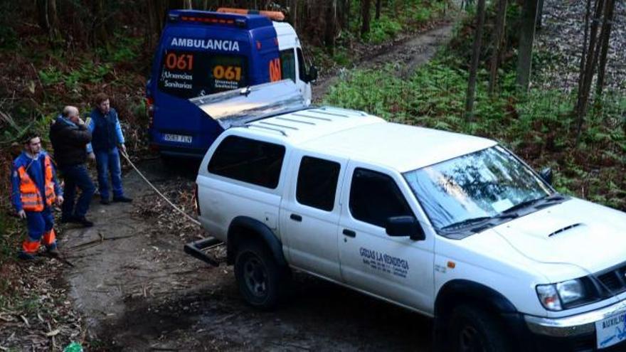 Maniobra para remolcar a la primera ambulancia que se quedó atrapada el miércoles en un camino de Bon, en Bueu.  // Gonzalo Núñez