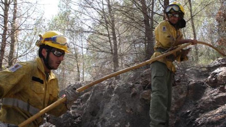 Varias personas continúan trabajando sobre el terreno quemado.