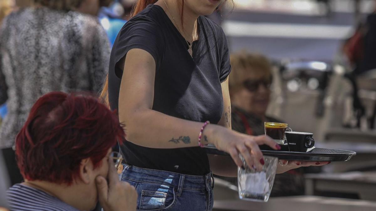 Una camarera atiende a unas clientas en una de las terrazas de la plaza de la Glorieta. | ANTONIO AMORÓS