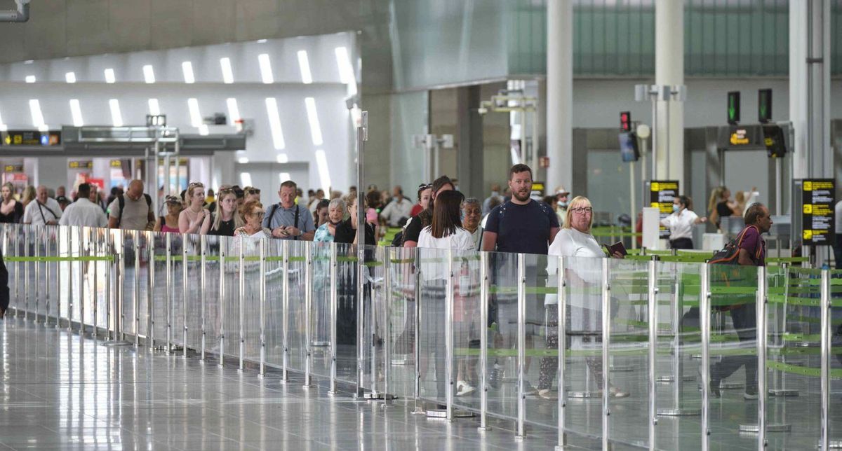 Pasajeros hacen cola para facturar los equipajes en la terminal del aeropuerto Tenerife Sur. | | CARSTEN W. LAURITSEN