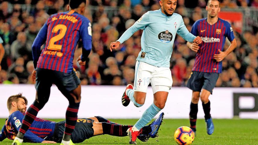 Boufal supera a Piqué, en el suelo, ante la presencia de Semedo y de Busquets, en el Camp Nou. // LOF