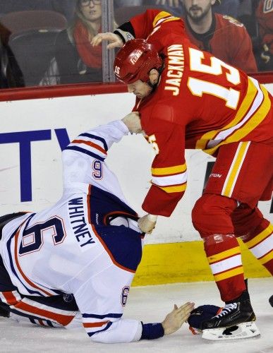 Tim Jackman (Calgary Flames) y Ryan Whitney (Edmonton Oilers) luchan en un partido de NHL