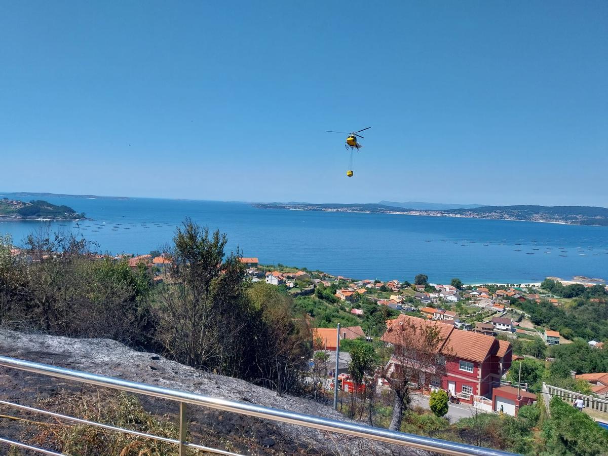 Un helicóptero durante las labores de extinción de un incendio el verano pasado en el lugar de A Barraca, en Bueu.