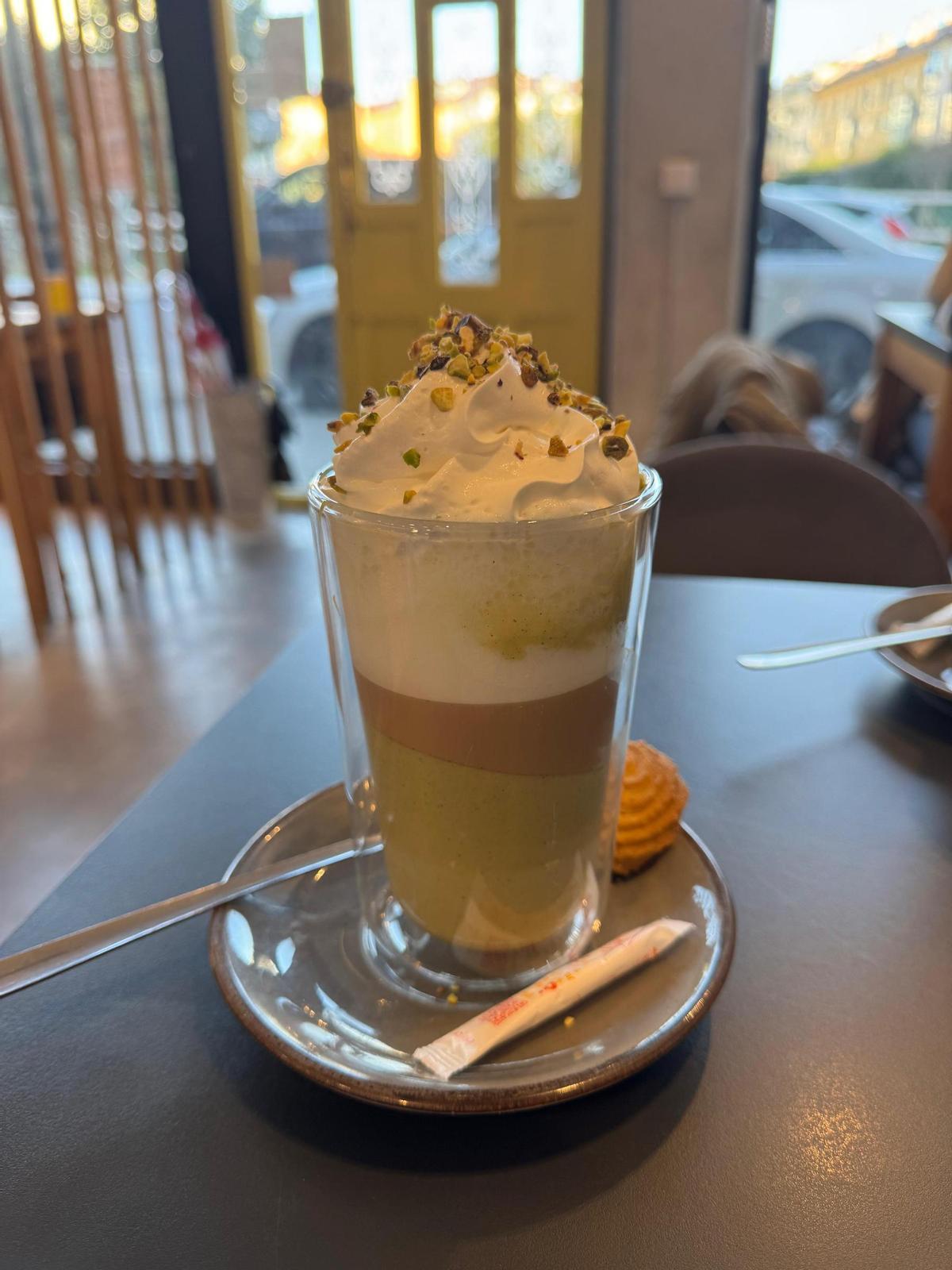 Un café con pistacho y la puerta amarilla de fondo