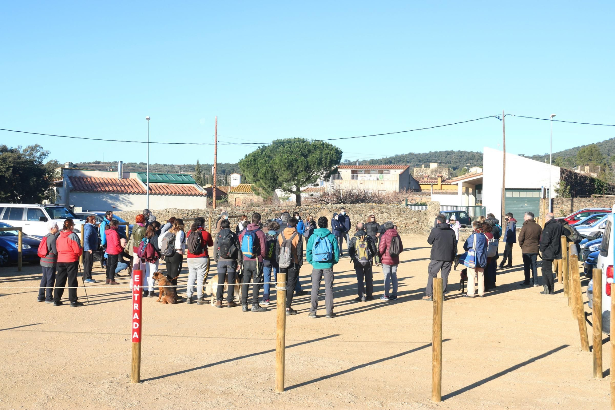 Els veïns d'Espolla que han participat en la caminada pujant al turó amb la vara que simula una pala de l'aerogenerador