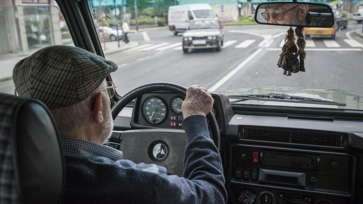 Una persona mayor, conduciendo su vehículo.