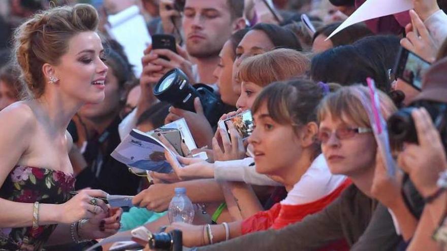 La actriz norteamericana Amber Heard firma autógrafos, ayer, en Venecia.