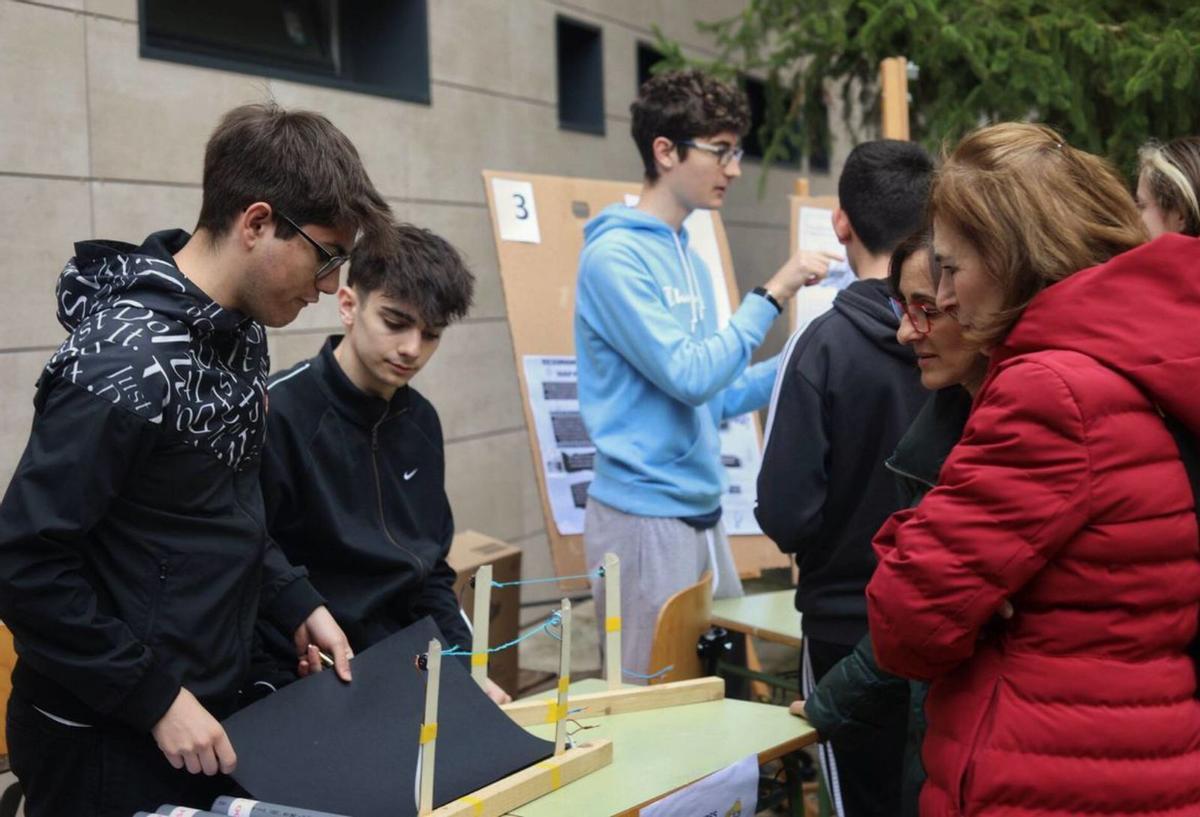 Dos alumnos explican uno de los fenómenos de ondas a los visitantes. | Alba prieto