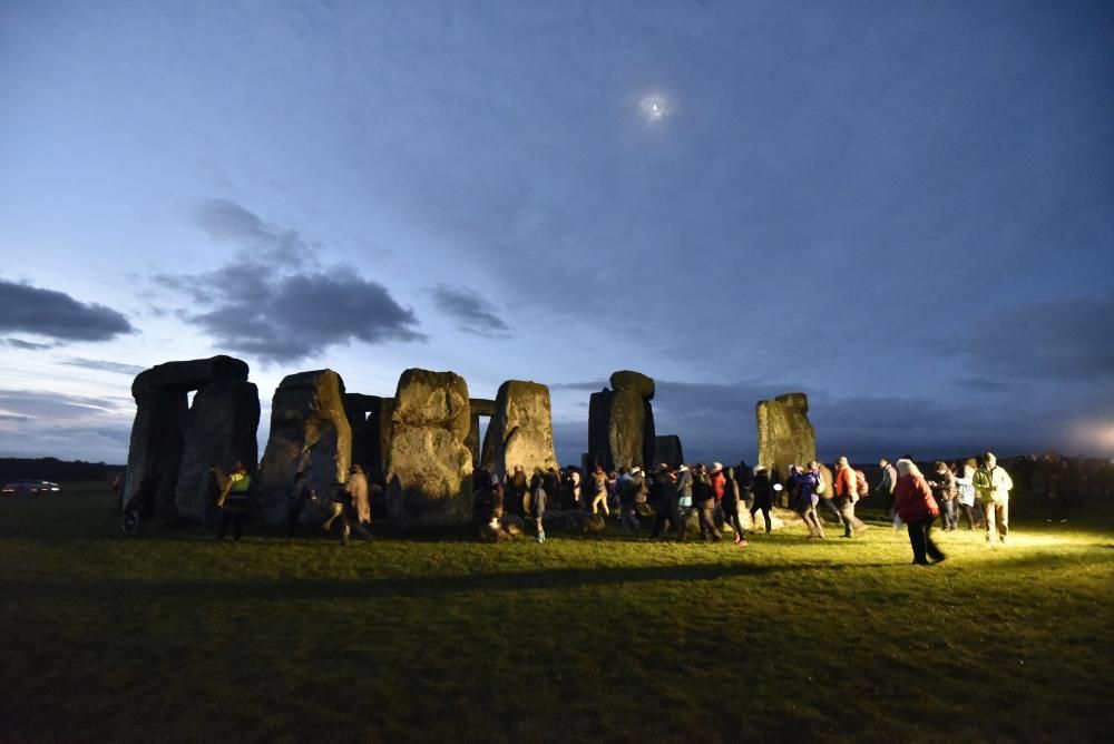Miles de personas, varias de ellas disfrazadas de druidas, acudieron hoy al monumento de Stonehenge en Inglaterra para ver el amanecer con motivo del solsticio de invierno.
