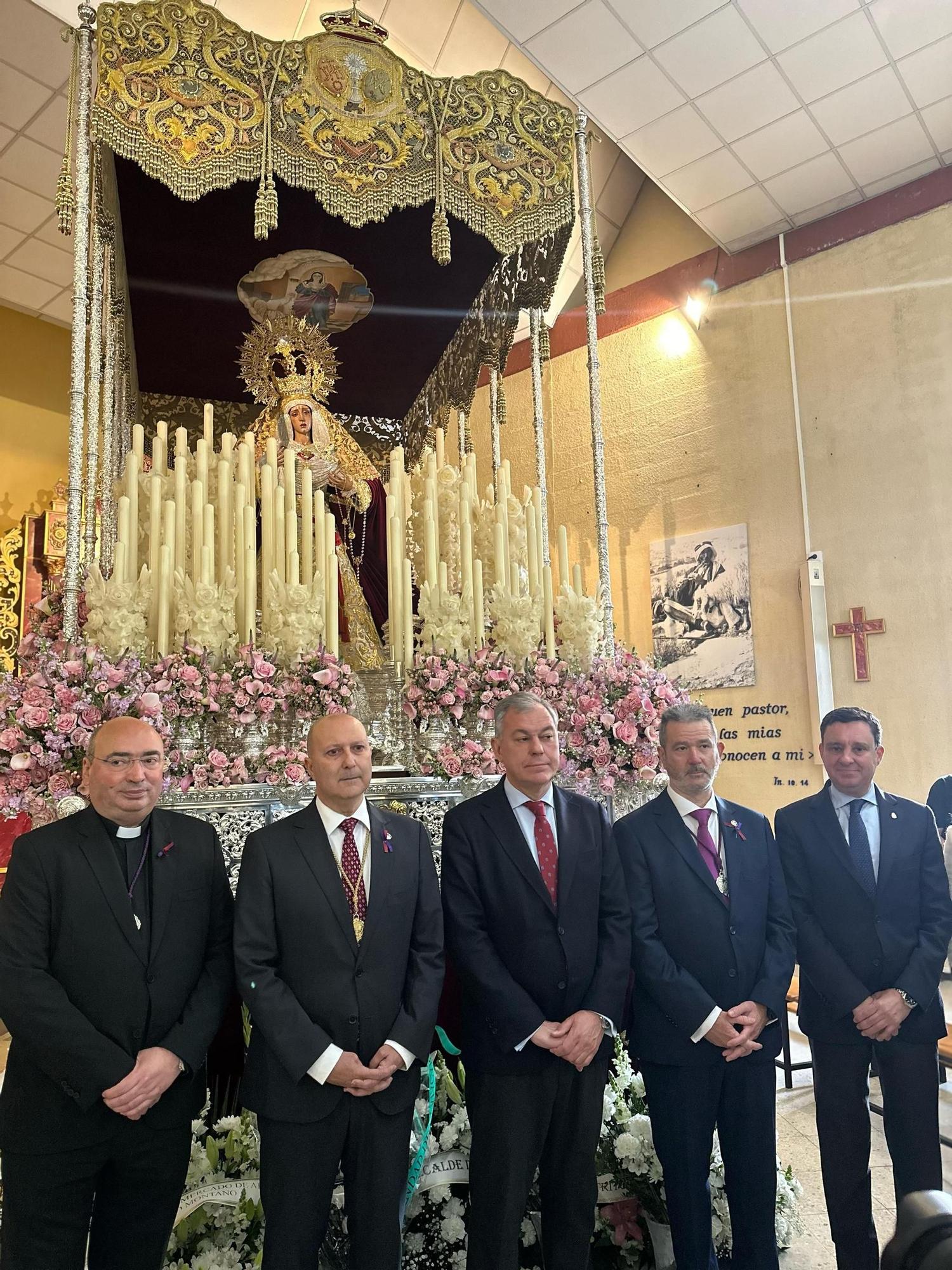 La comitiva del Ayuntamiento de Sevilla posa junto al Hermano Mayor de la Hermandad de Pino Montano frente al paso de Jesús de Nazaret.