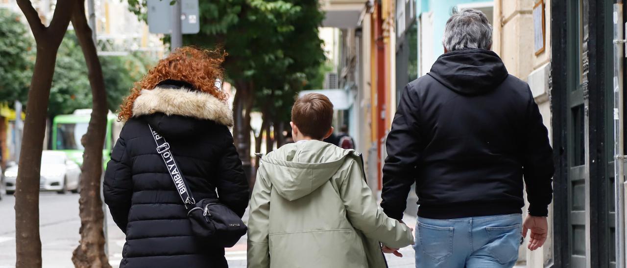 Una pareja pasea con su hijo menor de edad por una calle del centro de Córdoba.