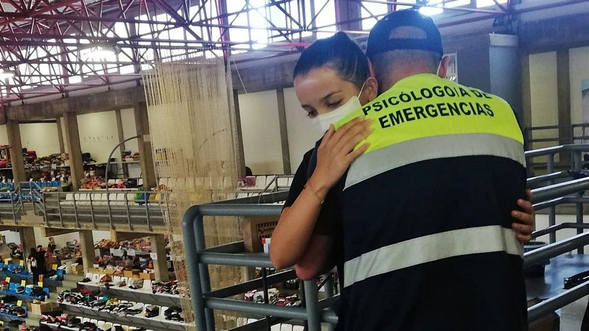 Felipe Lagarejo da un abrazo a una afectada por la lava del volcán de La Palma, en el polideportivo habilitado para acoger a los damnificados.