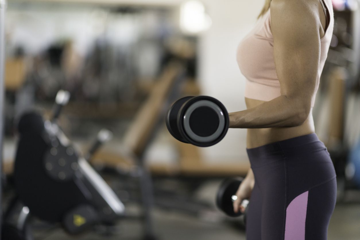 Mujer realizando pesas en el gimnasio