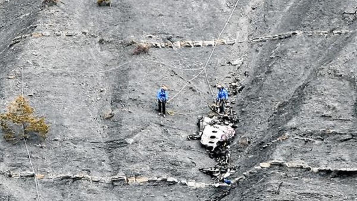 Un equipo de rescate en los Alpes trata de llevarse una pieza del avión estrellado de Germanwings, ayer.