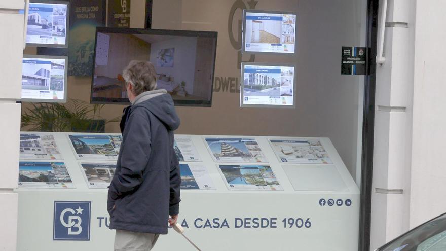 Un viandante observa el escaparate de una inmobiliaria en A Coruña.