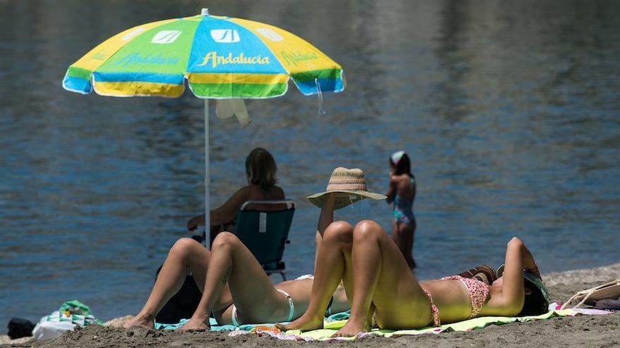 Dos jóvenes toman el sol en la playa, esta pasada semana.