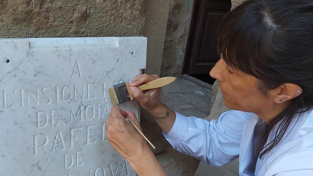 Cristina Casinos, encarregada de la conservació de peces del Museu de Moià, polint la placa