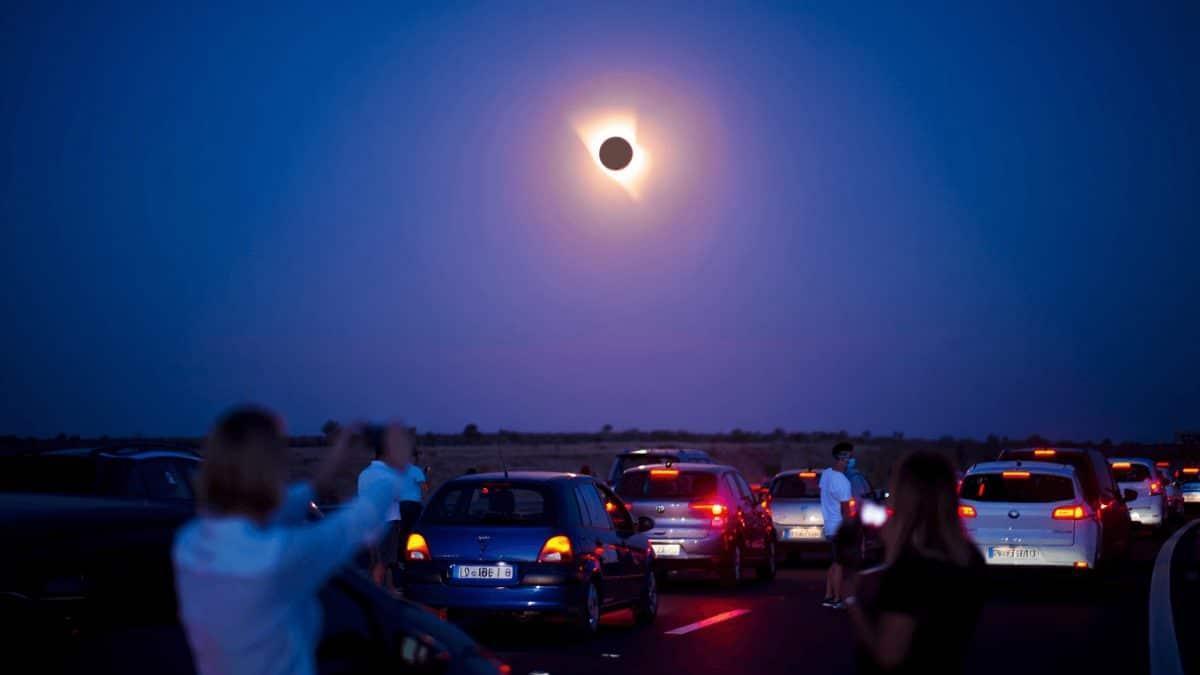 Persona mirando un eclipse desde la carretera.
