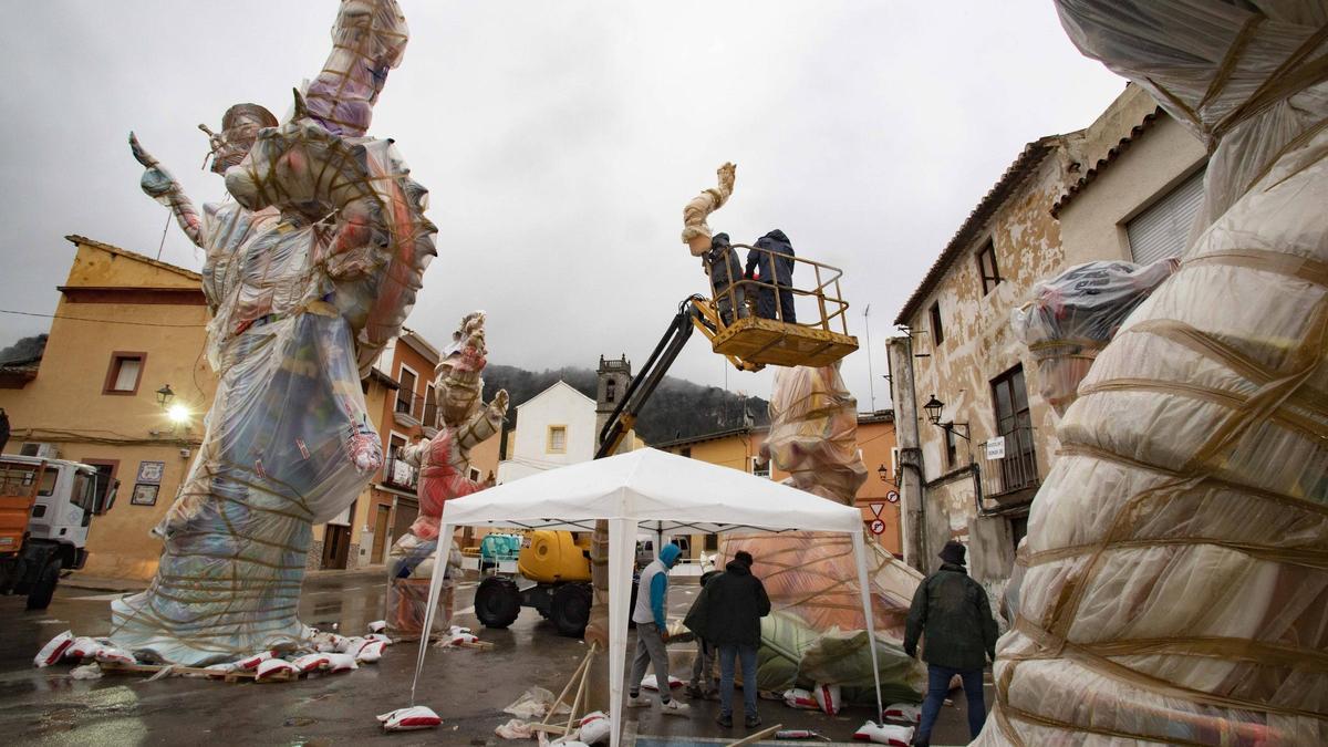 Trabajos de montaje en la falla Raval, con todo el monumento envuelto en plástico, este viernes.