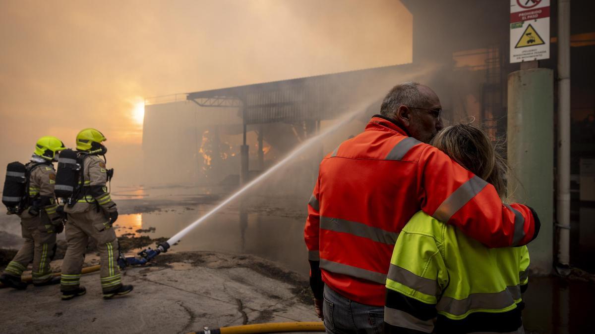 Los bomberos, en los trabajos de extinción del incendio, este domingo.