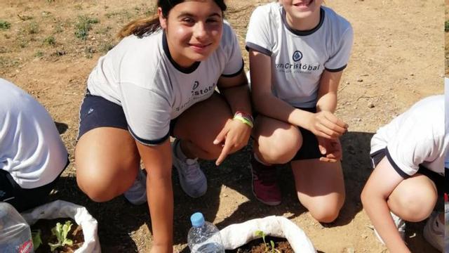 Dos alumnes del centre en l’hort escolar.