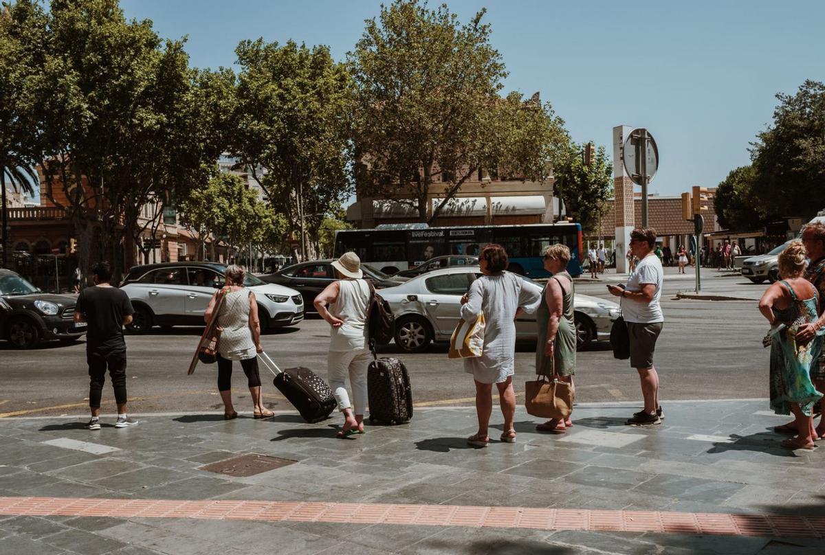Turistas esperando a pleno sol en la parada de plaza de España. | BERNARDO ARZAYUS