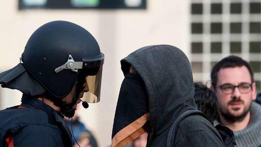 Un agente antidisturbios de los Mossos d&#039;Esquadra y un manifestante, durante las protestas del jueves en Gerona. // AFP