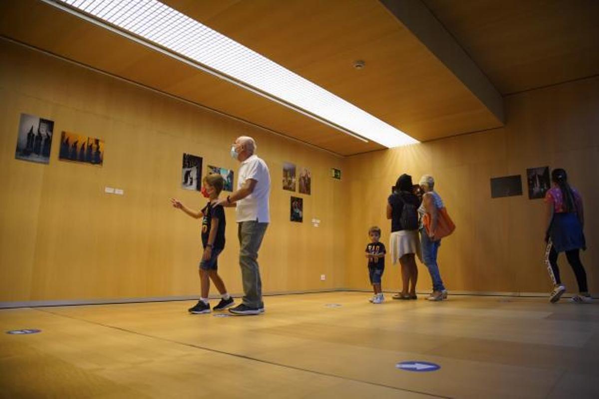 Varias personas contemplan una exposición.