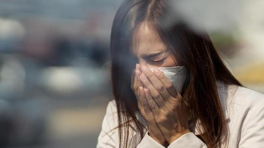 mujer con mascarilla estornuda.