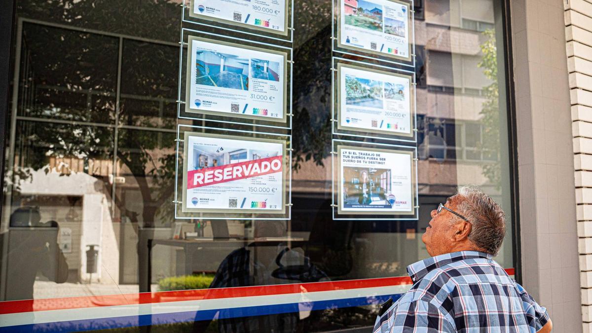 Un hombre viendo el escaparate de una inmobiliaria en Vigo.