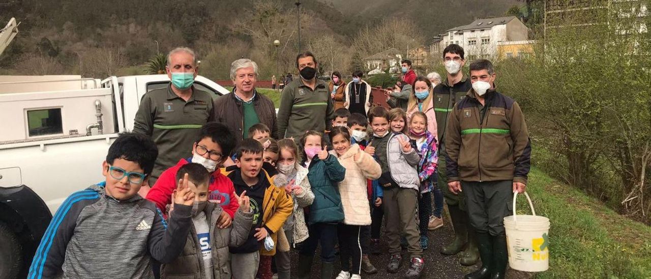 Escolares de Trevías, junto a pescadores y guardas, en la jornada de repoblación celebrada hace unos días en el Esva. | R. T. C.
