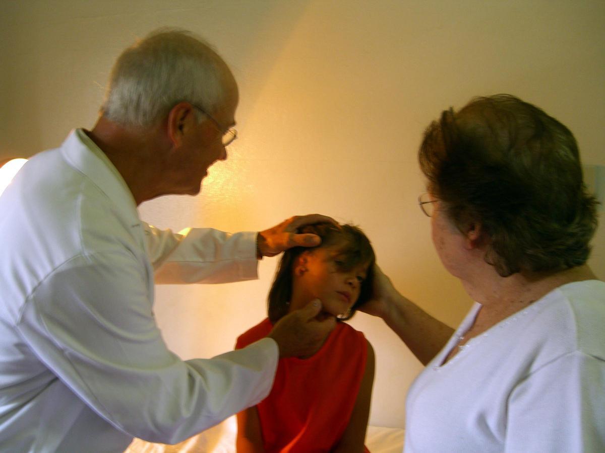 Un especialista inspecciona la oreja derecha de Jefferson, un niño con microtia.